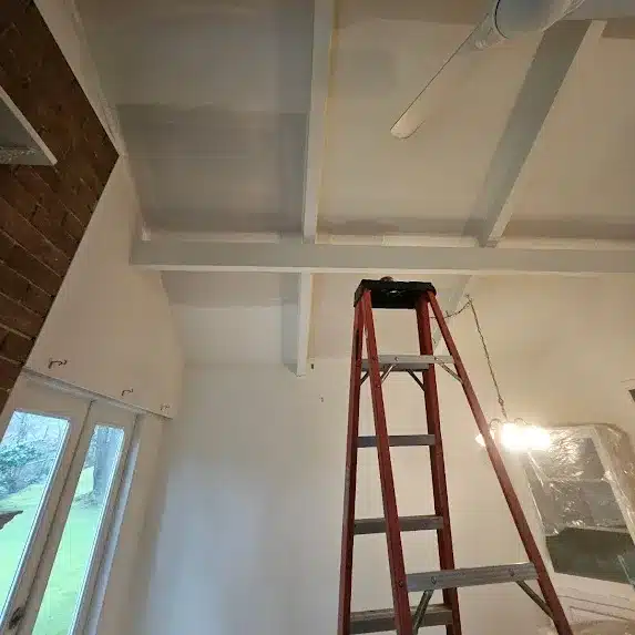 Ladder under white ceiling beams