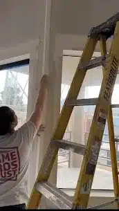 Person on ladder working indoors